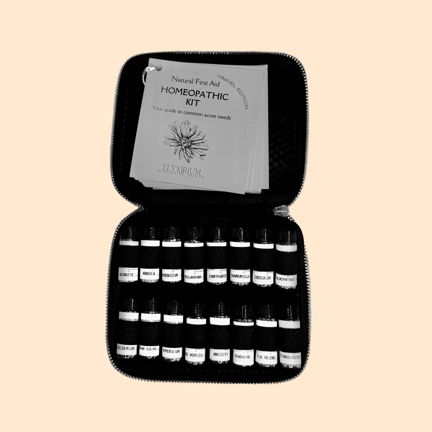 Homeopathic kit with bottles and a guide on a gray surface.